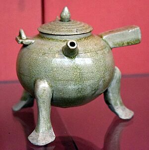 Ewer. Lidded tripod with handles, used for heating certain alcoholic drinks. Stoneware with pale green (celadon) glaze. Six Dynasties, 500-580 CE. Victoria and Albert Museum, London