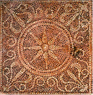 A red-orange mosaic displaying patterns and a central motif of a star-like symbol