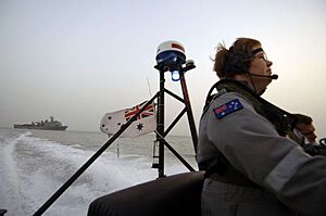 US Navy 050704-N-4309A-443 Australian Petty Officer ET Tarah Clark, stationed aboard the guided missile armed frigate HMAS Newcastle (FFG 06), drives a Rigid Hull Inflatible Boat (RHIB) back to her ship after making a passenger