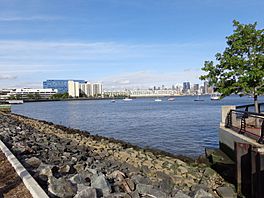 A photo looking north from Hoboken, NJ showing Weehawken, NJ on the left side and across the Hudson River Manhattan is viable.