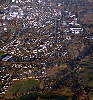 Greenfaulds from the air photographed from above Condorrat. The rugby club is at the bottom with Greenfaulds High School on the right. The view is up the railway line with the Town Centre in the background. Carbrain is above Greenfaulds with Lenziemill to the right.