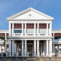 Front façade of a white Palladian-style courthouse prominently featuring columns supporting the pediment and entablature.