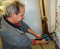 Plumber uses two wrenches to tighten a fitting