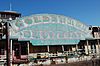 A faded blue, pink, and gold sign sits on the side of a rusting showboat and displays the words, "GOLDENROD / NATIONAL LANDMARK / SHOWBOAT / St. Charles, Missouri"