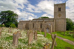 A long stone church in a graveyard, see from the northeast, with a north vestry, and a tower at the far end