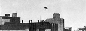 A monochrome picture of an aircraft, minus its tailplane and outer wing tips diving onto a rail station