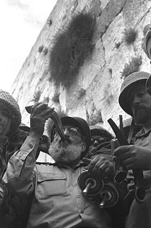 Six Day War. Army chief chaplain rabbi Shlomo Goren, who is surrounded by IDF soldiers, blows the shofar in front of the western wall in Jerusalem. June 1967. D327-043