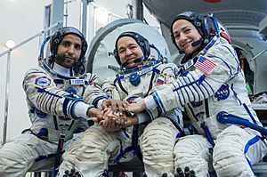 Soyuz MS-15 crew in front of the Soyuz spacecraft simulator (cropped)