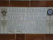 A tablet formed of five tiles of varying sizes, bordered by yellow and blue flowers in an art nouveau style