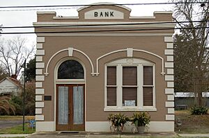 A one-story brick building with taupe paint and the word "BANK" on the top.