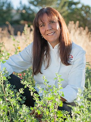 Woman in chef's whites sitting in a field