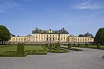 Palace with a yellow facade and green roof, park in front