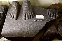 Base of a granite statue inscribed with the name of Senusret (Sesostris) I. Two feet of a female figure, at the right side of the right foot of the king. From Armant, Egypt