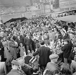 Een standwerker prijst zijn koopwaar aan, Bestanddeelnr 191-0928