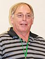 A blonde-haired man with glasses and a striped shirt