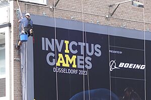 Invictus Games in Düsseldorf, Fassadenkletterer bei der Installation eines Großplakats, 22. August 2023 (1)