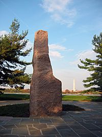 Triangular sandstone rock with Washington Monument in the background