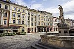 Old colourful town houses and a fountain with a statue in front