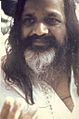 Closeup portrait of an Indian man with long black hair and mustache, and white beard