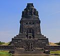 monument commemorating the battle, tall square block, soldier on top, images of soldiers around the monument