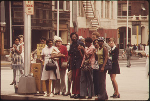 COMMUTERS ON A STREET CORNER IN DOWNTOWN ATLANTA GEORGIA, WAITING FOR A METROPOLITAN ATLANTA RAPID TRANSIT AUTHORITY... - NARA - 556808