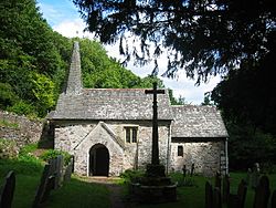 A small stone church surrounded by trees