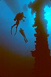 Divers next to the mast of the Unkai Maru wreck, Truk Lagoon, Micronesia