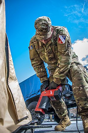 A member of the 1st Governor's Foot Guard drills a pilot hole