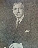 A black-and-white photograph of a man in a suit with a tie