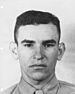 A head and shoulders portrait of a young, cleanshaven man with dark hair.