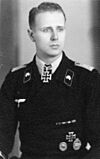 A man wearing a military uniform with an Iron Cross displayed at the front of his uniform collar.