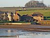 Stone buildings with water in front.