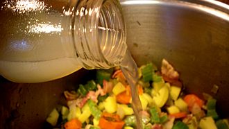 Clam juice being used in preparation of clam chowder