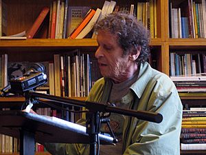 An elderly man reading from a lectern