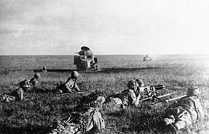 Japanese soldiers creeping in front of wrecked Soviet tanks.jpg