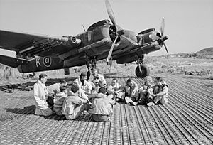 Aircrew of No. 16 Squadron SAAF and No. 227 Squadron RAF sitting in front of a Bristol Beaufighter at Biferno, Italy, prior to taking off to attack a German headquarters building in Dubrovnik, Yugoslavia, 14 August 1944. C5894