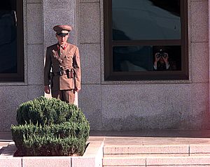 Korean People's Army Soldiers watch as preparations for a repatriation ceremony are made at the Panmunjom Joint Security Area on 981106-F-AF179-509